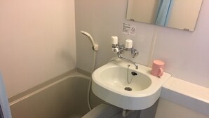 A bathroom with a white sink, a bathtub, and a toilet. There is a towel hanging on the wall. - Minshuku Sumitomo (Hakodate)