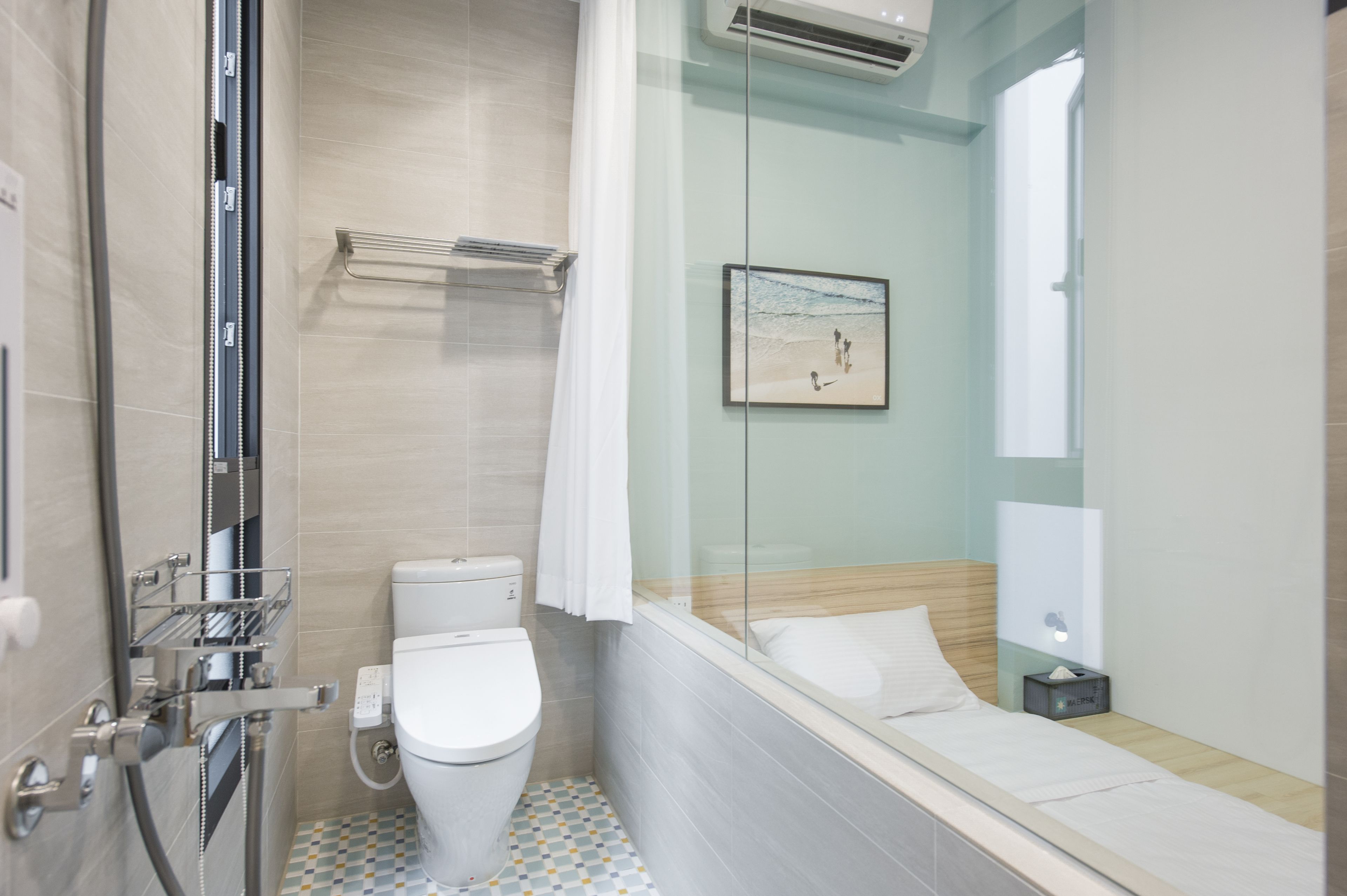 A modern bathroom with a shower, toilet, and a glass-enclosed bathtub.