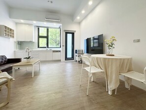 A modern living space with a kitchen, dining area, and seating. - OX Suites (Kaohsiung)