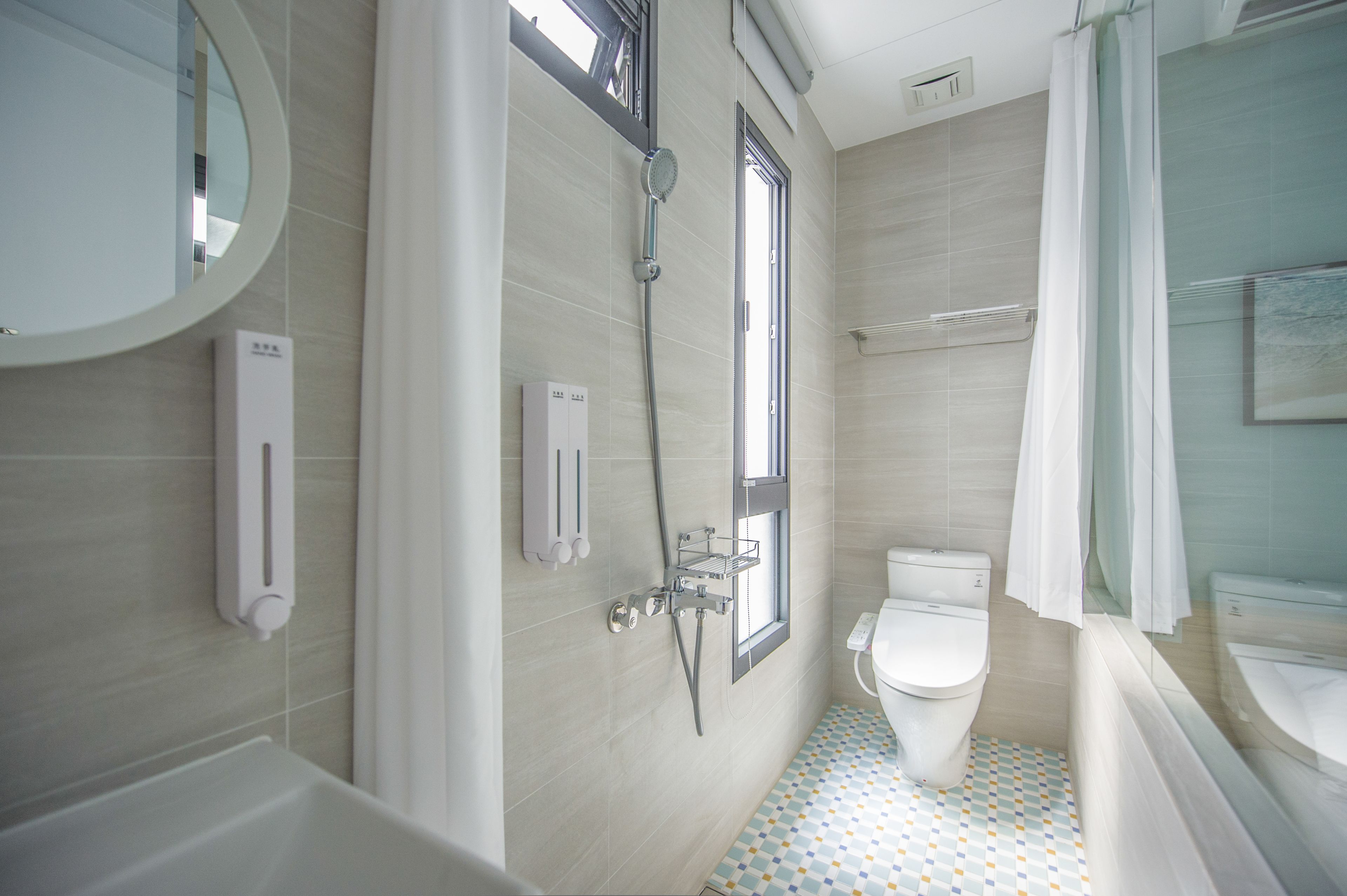 A modern bathroom with a toilet, shower, and bathtub.