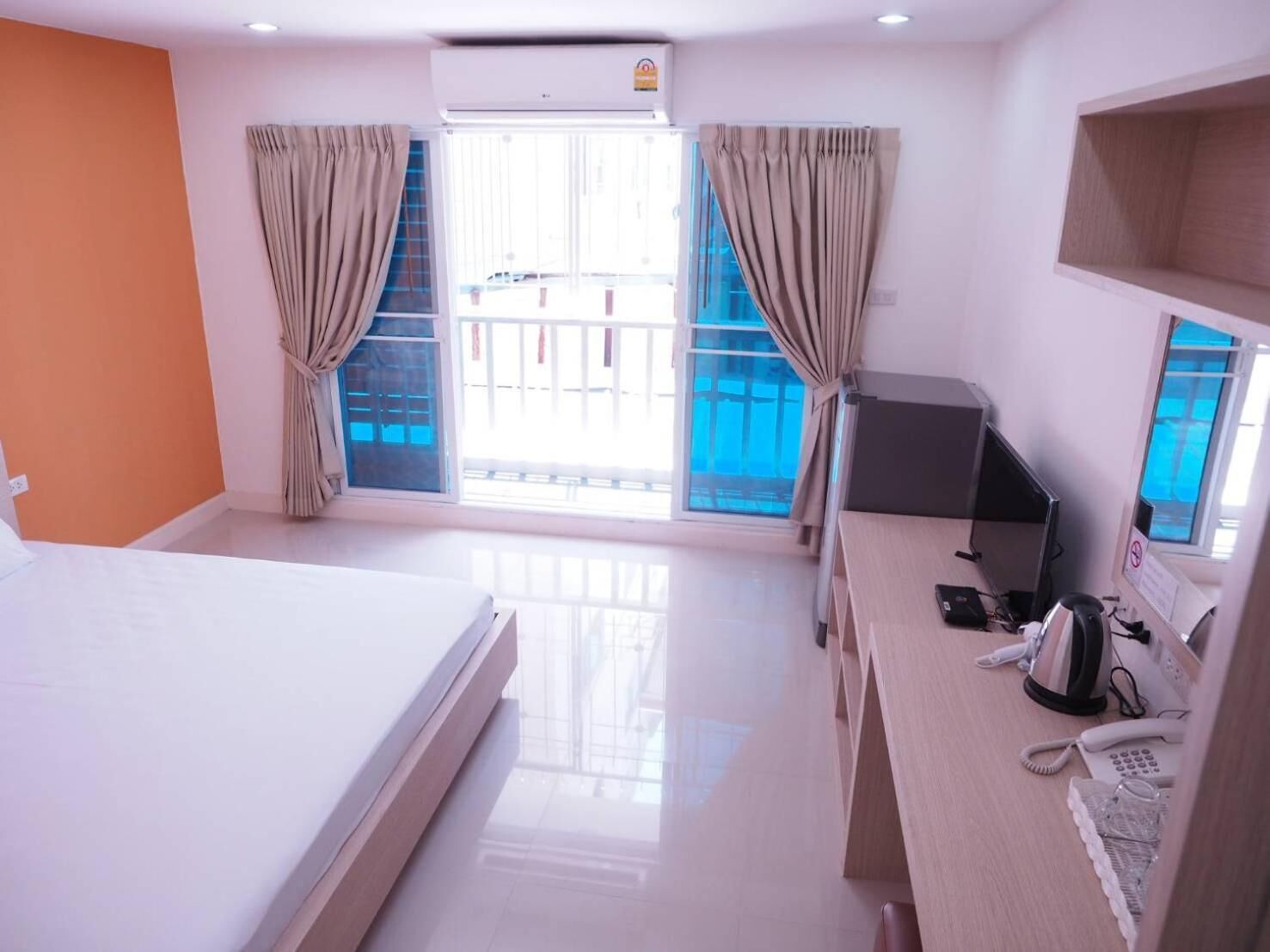 Una habitación de hotel con cama, escritorio y teléfono.