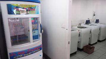 A laundry facility with a large water dispenser and multiple washing machines.