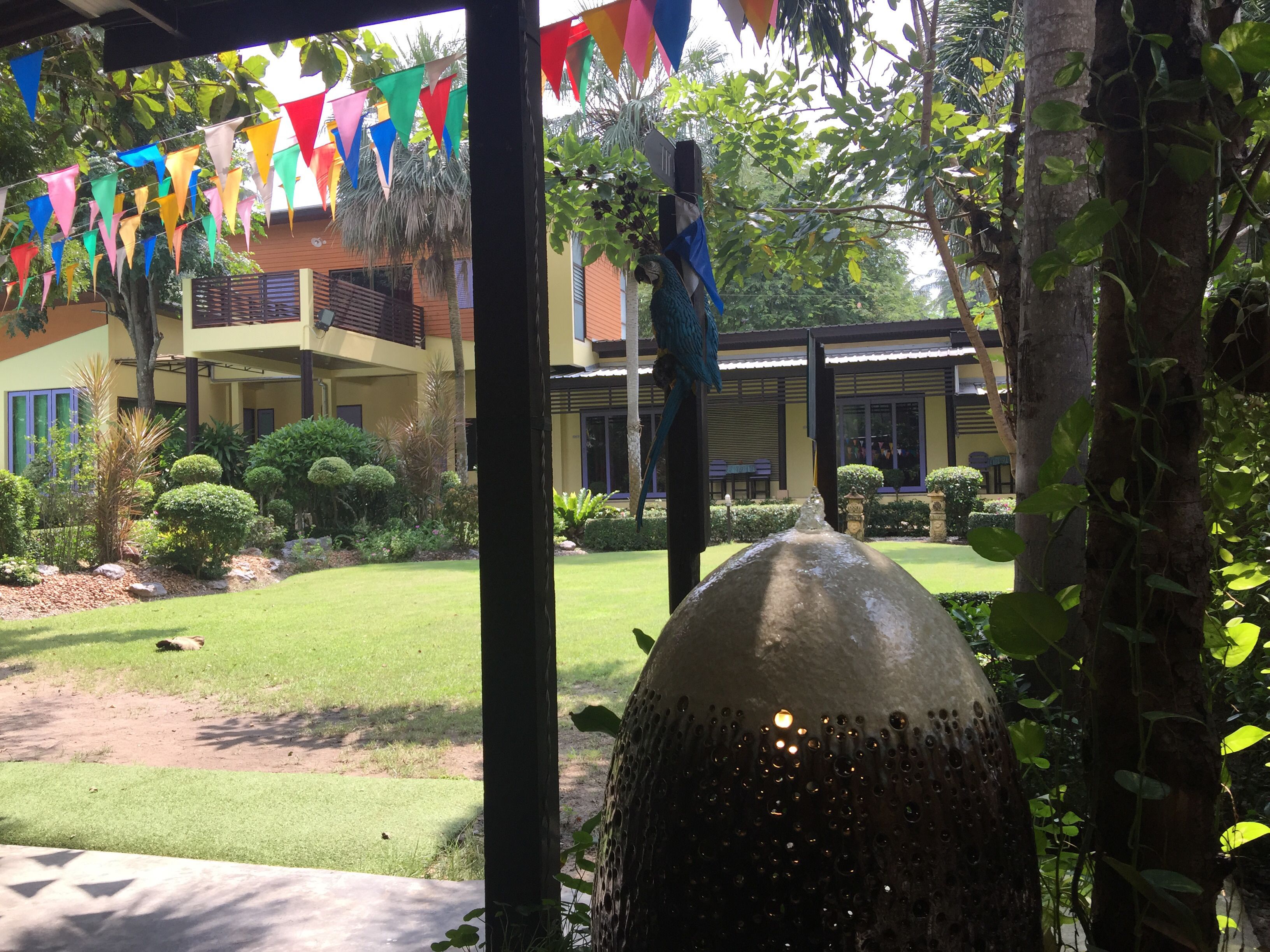 A courtyard with a fountain, colorful triangular flags, and a building with a balcony.