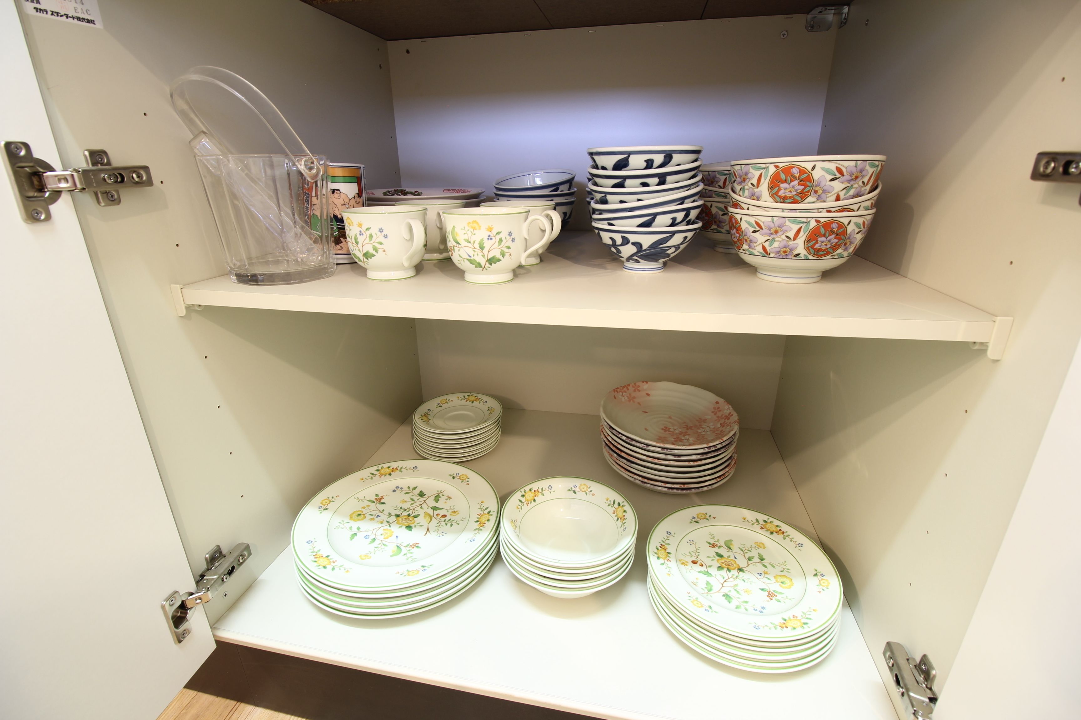 A storage area with shelves holding stacks of plates and bowls.
