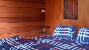 A wooden cabin room with a bed, a small table, and a window. - Maekampong Kidteng (Mae On)