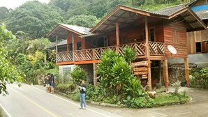 A wooden building with a balcony, surrounded by lush greenery. - Maekampong Kidteng (Mae On)