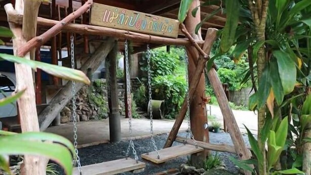 A wooden swing set with a sign in a natural setting. - Maekampong Kidteng (Mae On)