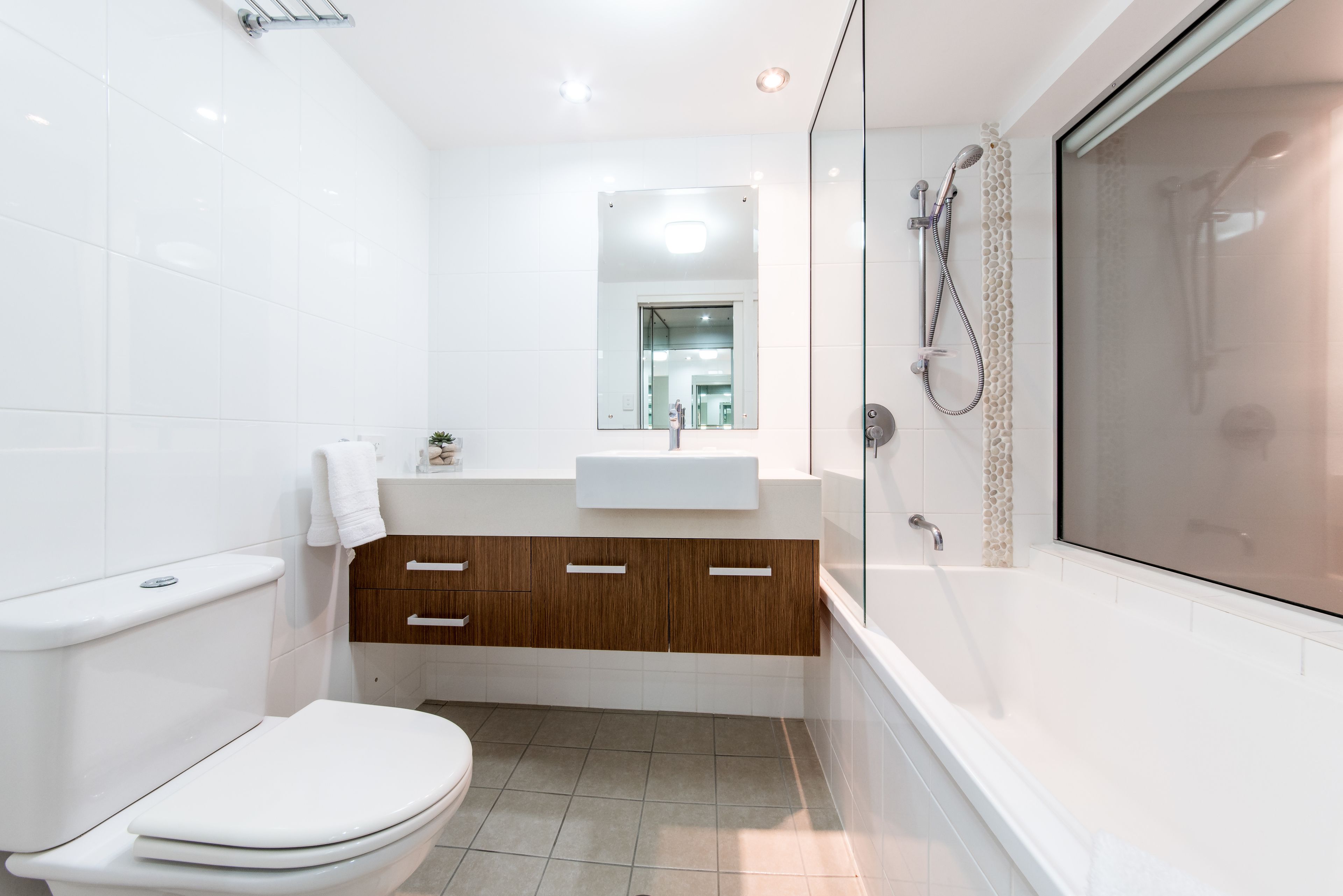 Un baño moderno con inodoro, lavamanos, tocador y cabina de ducha.