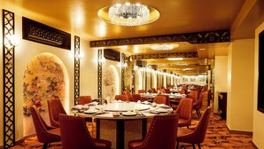 A formal dining room with round tables, red upholstered chairs, and a chandelier. - Sam Royal Apartment (Ho Chi Minh City)