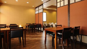 A dining area with wooden tables and chairs, a large window, and a view of the outside. - Gensen no Yado Maruishi Ryokan (Hakuba)