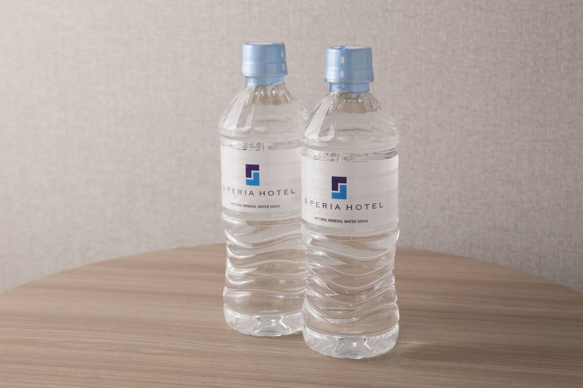 Deux bouteilles d’eau portant l’étiquette « Speria Hotel » sont posées sur une surface en bois.