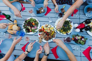A group of people dining at a table with various dishes and drinks. - Stockholm Studios (Irpin)