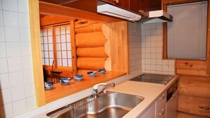 Una cocina con un lavamanos, armarios de madera y una ventana con vistas.