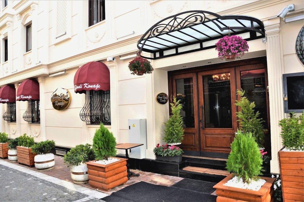 A building with a classic facade, a wooden door, and a black awning.