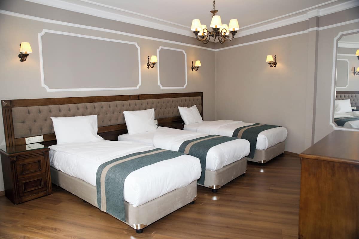 Habitación triple Deluxe, vista parcial al mar | Ropa de cama de alta calidad y caja de seguridad en la habitación