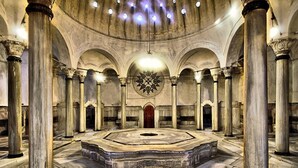 Un vaste hall aux hauts plafonds, doté de grandes colonnes et d’une plateforme circulaire centrale.