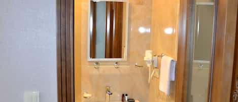 Un baño con lavamanos, espejo y ducha.