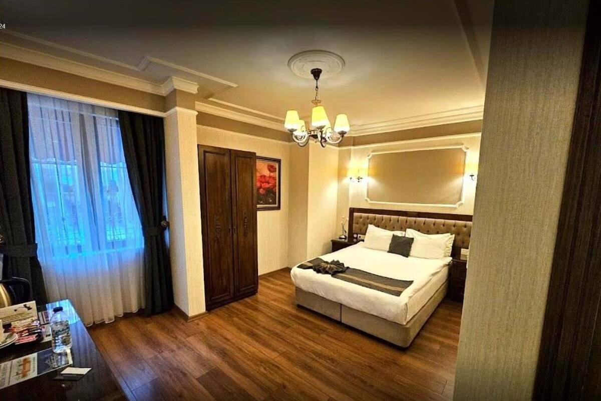 أغطية فراش متميزة وخزنة داخل الغرفة ومكتب وستائر تعتيم