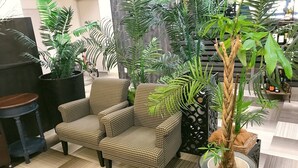 A room with a patterned armchair, a potted plant, and a checkered floor. - Apoa Hotel Tsu (Tsu)