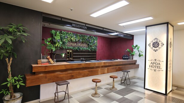 A reception desk with a wooden counter, a reception area, and a check-in counter. - Apoa Hotel Tsu (Tsu)