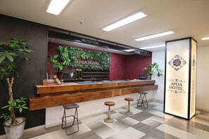 A reception desk with a wooden counter, a reception area, and a check-in counter.
