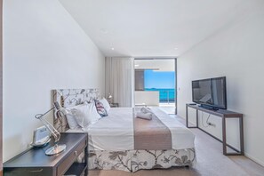 Una habitación de hotel moderna con una cama grande, un televisor y un balcón con vistas.