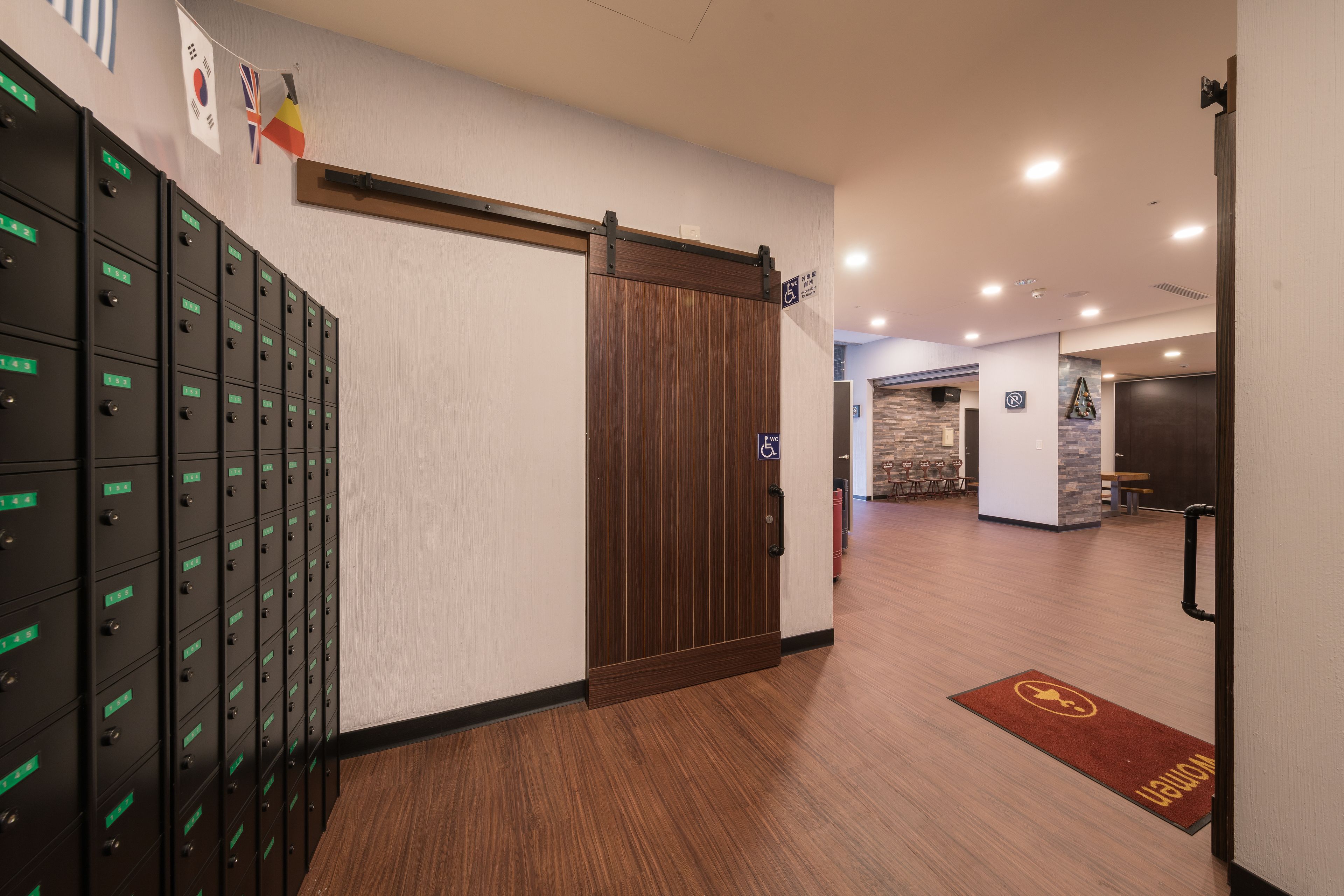 A hotel lobby with a sliding door, a row of lockers, and a reception desk.