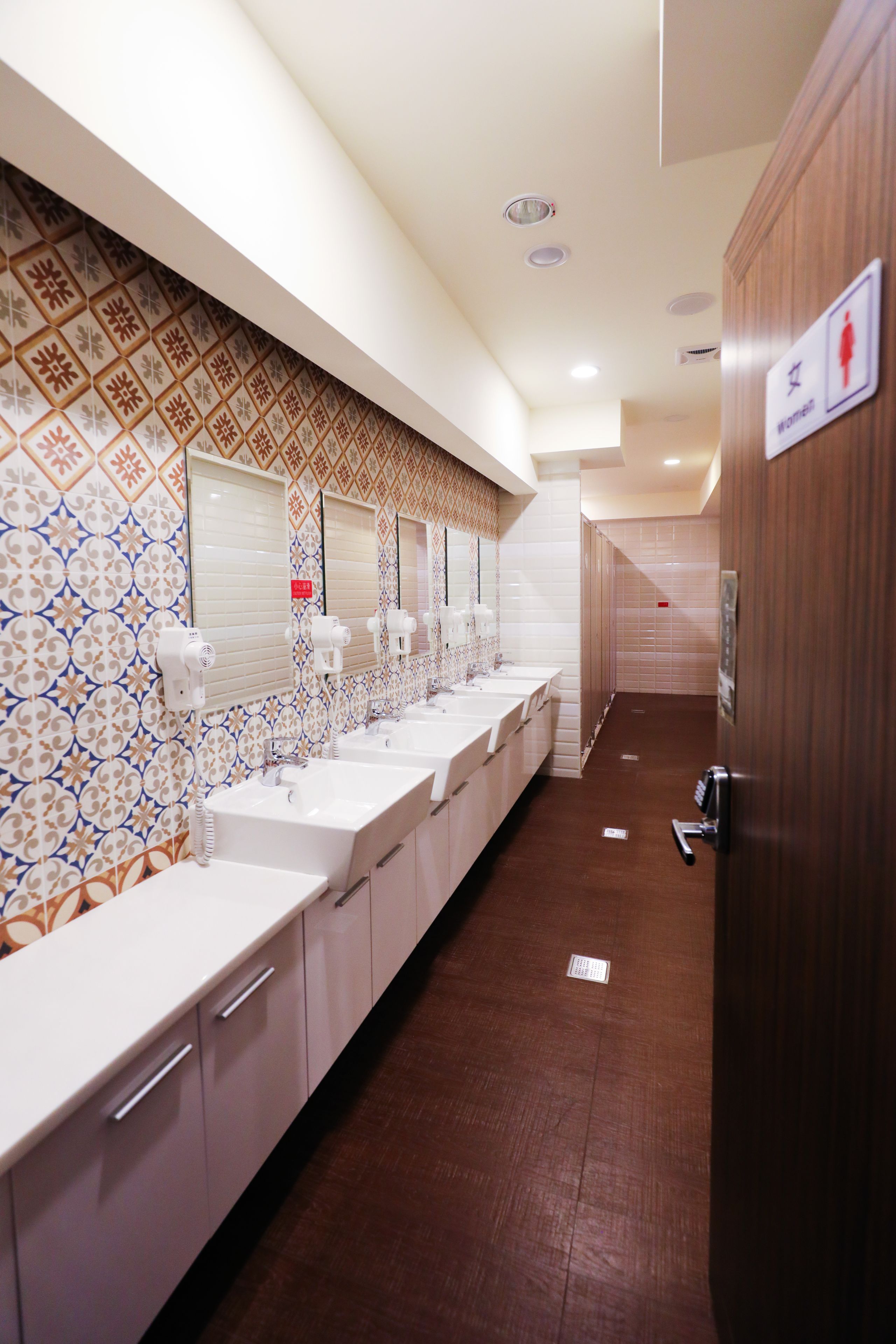 A long, narrow bathroom with multiple sinks and mirrors.