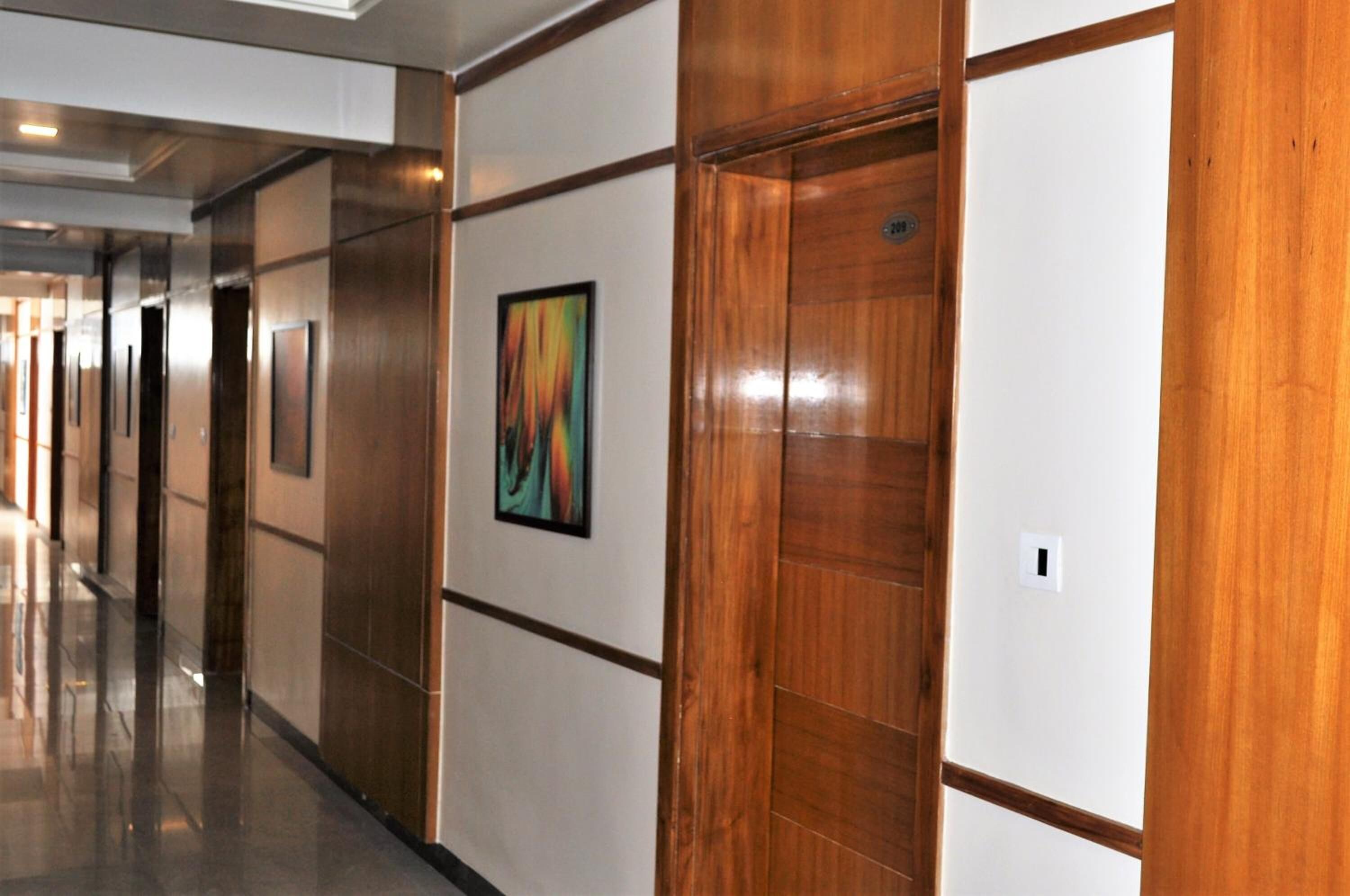 A hallway with wooden paneling and a framed artwork on the wall.