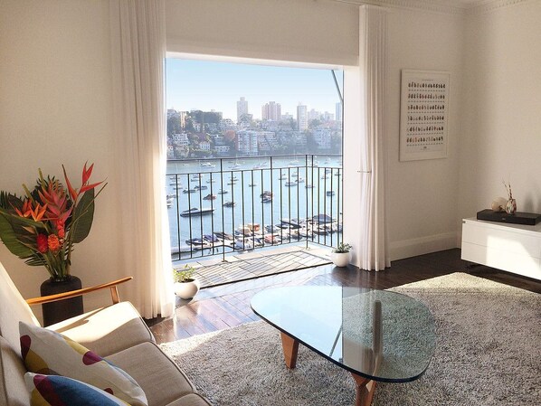 Relax in a stylish living room with a sofa, coffee table, and scenic marina views.