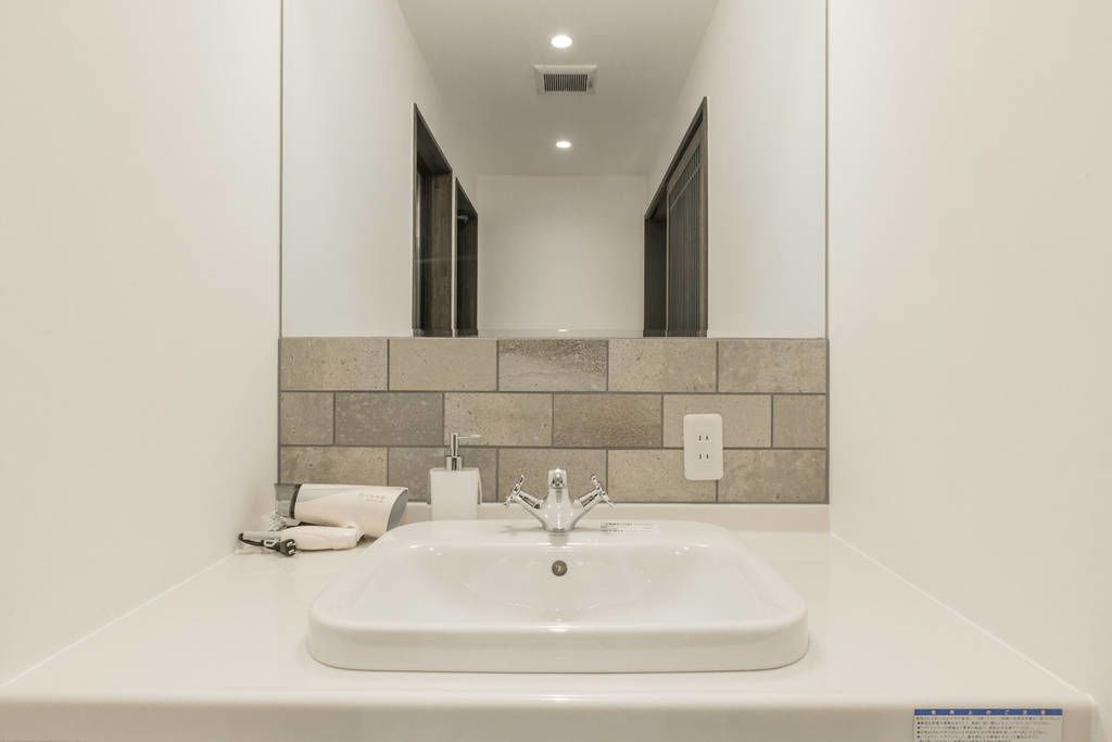 A bathroom with a white sink, a mirror, and a towel on the counter.