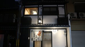 En traditionell japansk byggnad med en skjutdörr, en lykta och ett litet fönster.