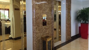 A hotel lobby with marble walls, a reception desk, and a large potted plant. - Halong Diamond Hotel (Bai Chay)