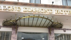 The exterior of the Long Diamond Hotel with a prominent entrance, a glass facade, and a metal canopy over the entrance. - Halong Diamond Hotel (Bai Chay)