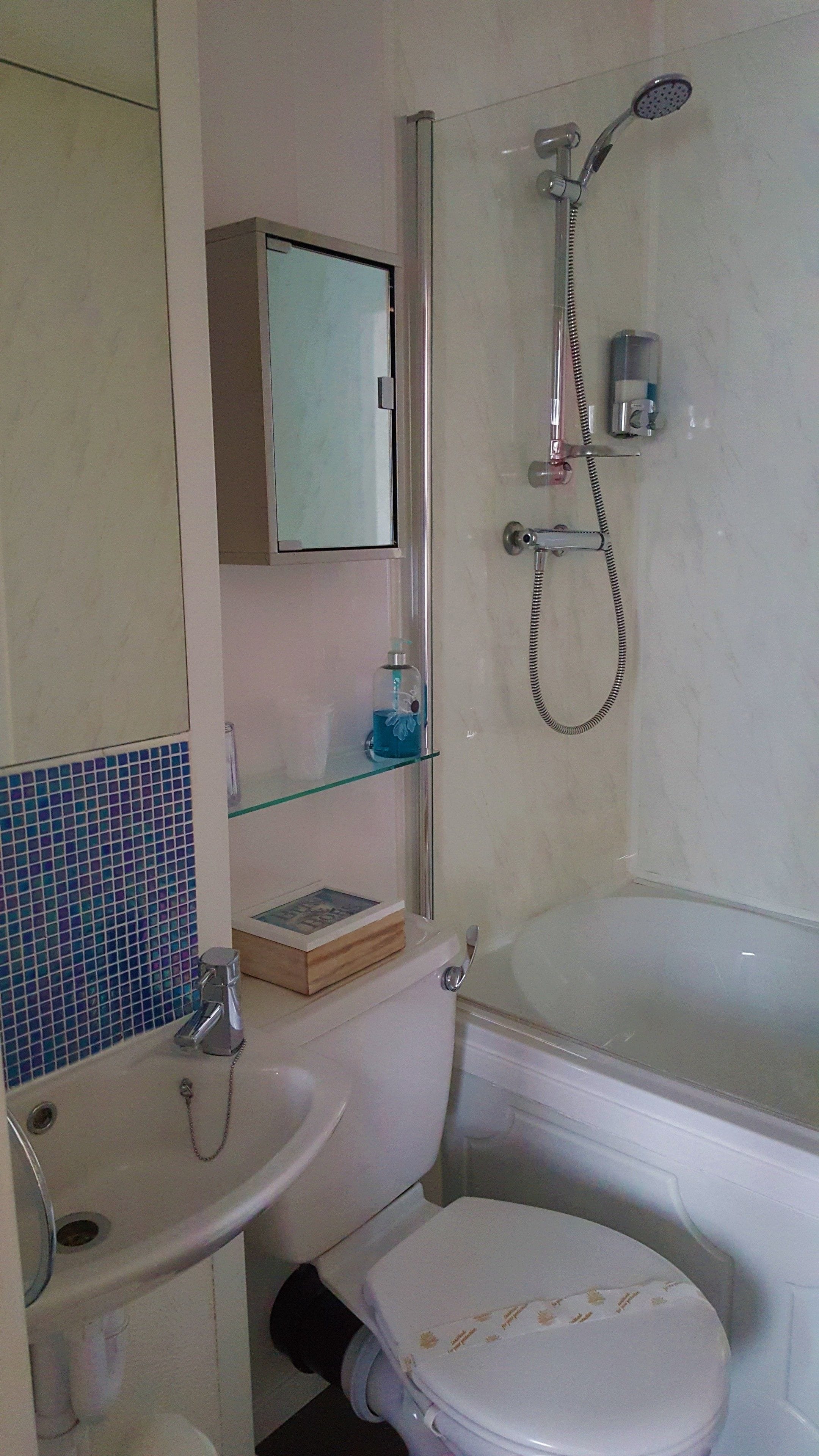 A bathroom with a toilet, sink, and shower.