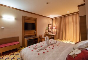 Une chambre d’hôtel équipée d’un lit, d’une télévision, d’un bureau, d’une chaise et d’une table de chevet.