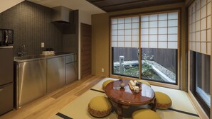 Una cocina moderna con comedor, que cuenta con un amplio ventanal corredero con vistas a un jardín.