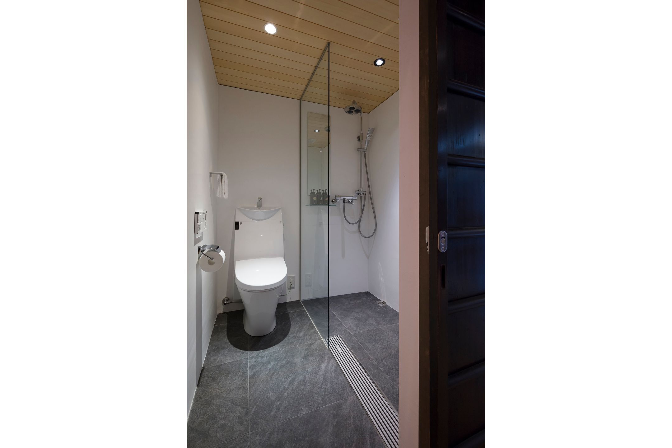 A modern bathroom with a toilet, sink, and shower.