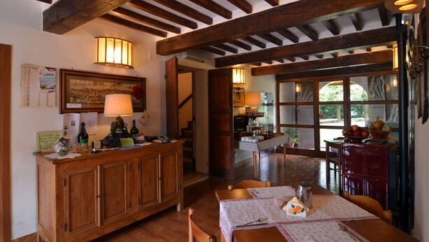 A rustic dining area with wooden beams, a wooden cabinet, and a table set for dining. - B&B Reboglio (Rolo)