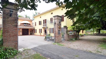 Traditional Italian villa with an entrance, balcony, and garden.