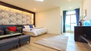 Une chambre d’hôtel moderne, équipée d’un lit, d’un canapé et d’un mur décoré avec un motif représentant un paysage urbain.