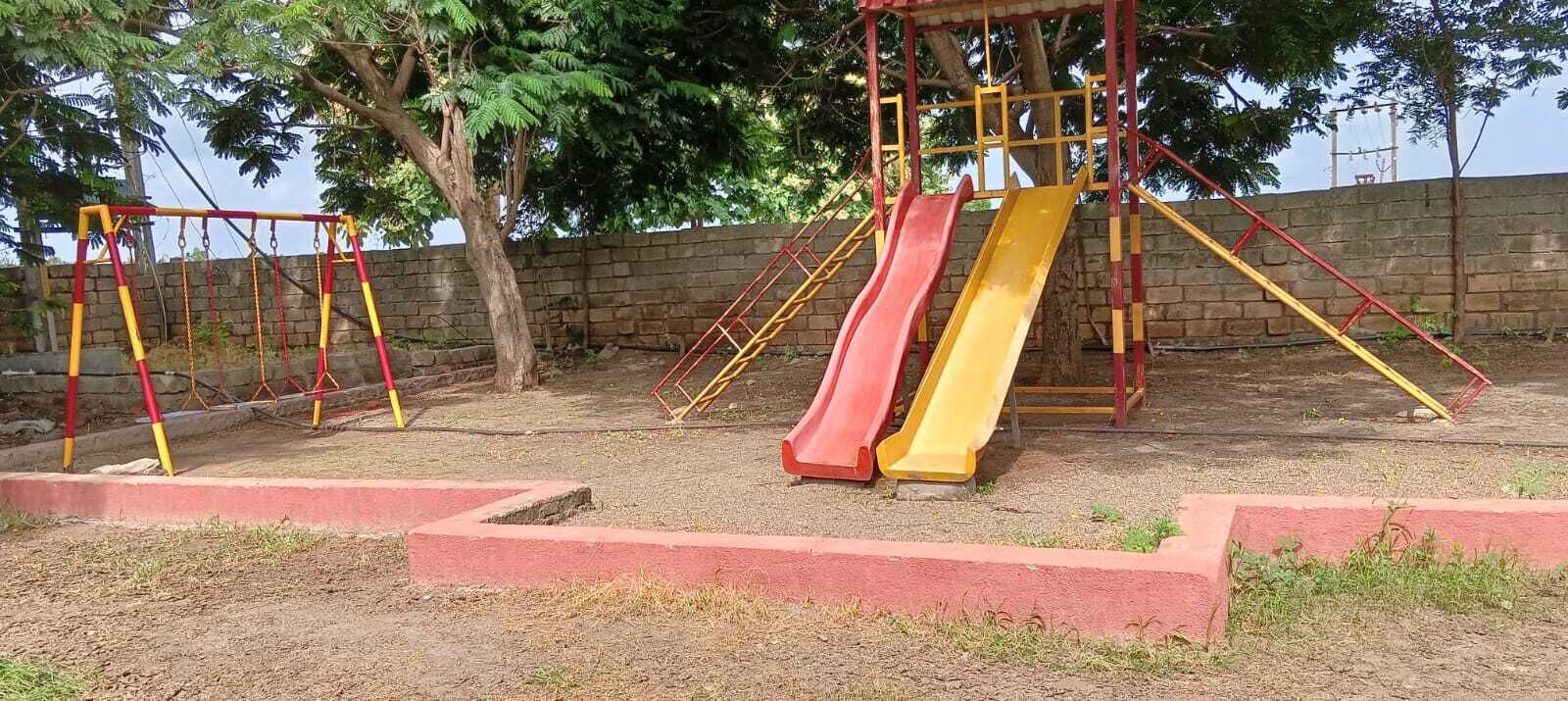 Ein Spielplatz mit Schaukeln und Rutschen.