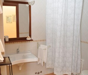A bathroom with a sink, mirror, and shower curtain. - Agriturismo Le Dolci Colline (Valfabbrica)