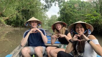 Drie mensen in een boot, omringd door weelderige begroeiing.