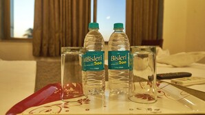 A una taula d'habitació d'hotel, hi ha un safata amb dues amples de Bisleri i dos vasos.