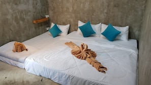 A bed with white bedding, teal pillows, and a swan-shaped towel arrangement. - A-Mote Loft at Phitsanulok (Phitsanulok)