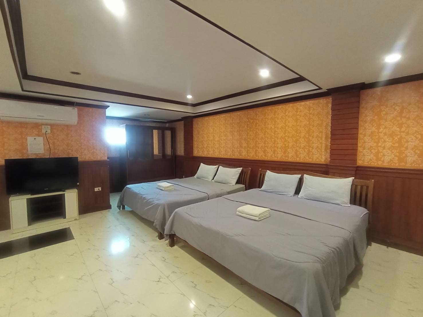 Habitación de hotel con dos camas, televisión y un minibar.