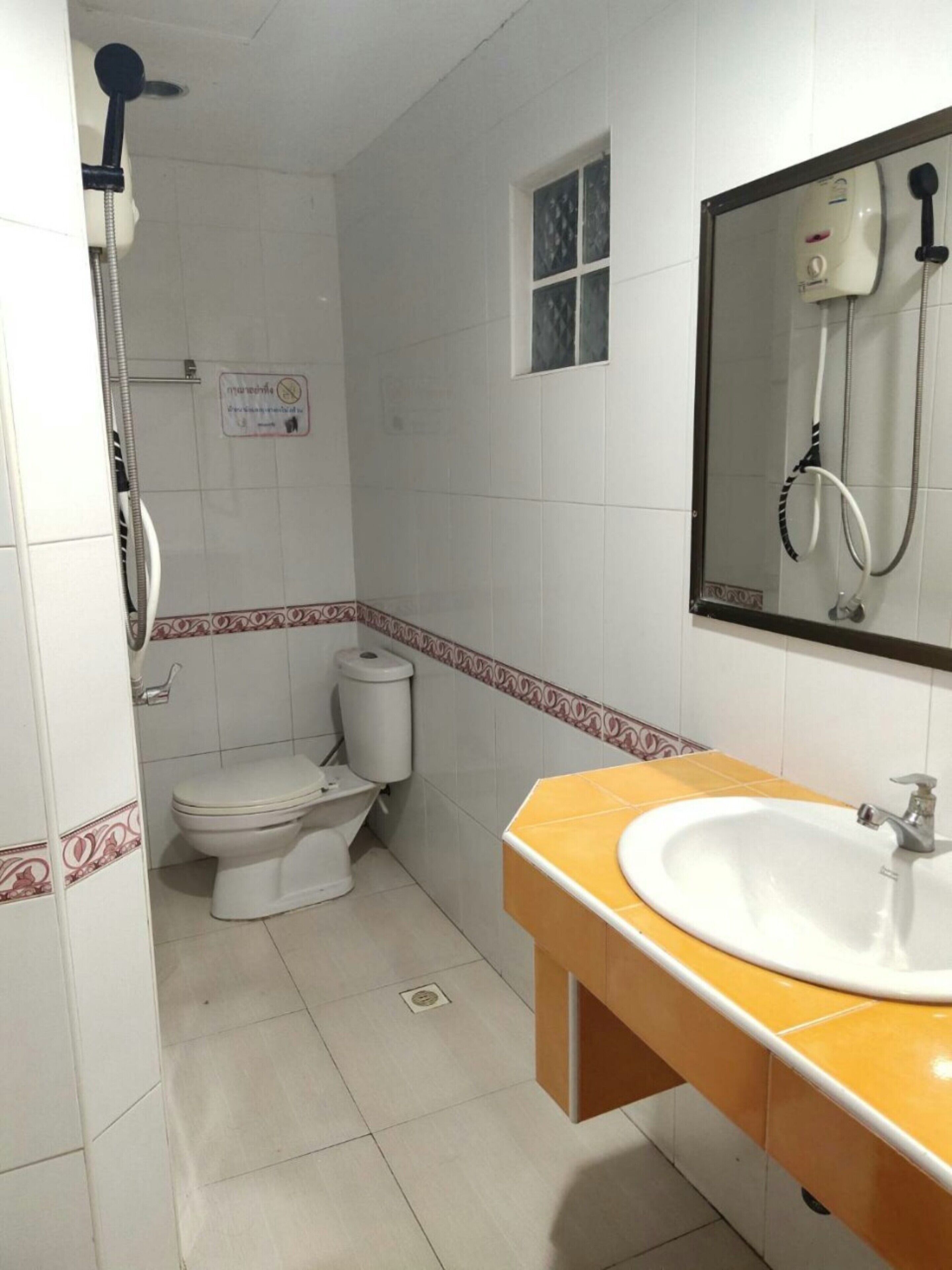 A bathroom with a toilet, a sink, and a shower.