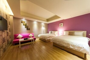 A bedroom with two beds, a pink sofa, and a small table. - X Square (Luodong)