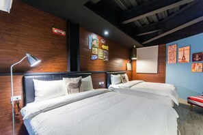 Een hotelkamer met twee bedden, houten wanden en verschillende posters.